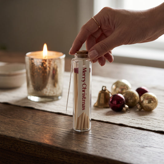 Mellow Monkey glass bottle match holder with red-tipped matches, cork stopper, and Merry Christmas wood tag