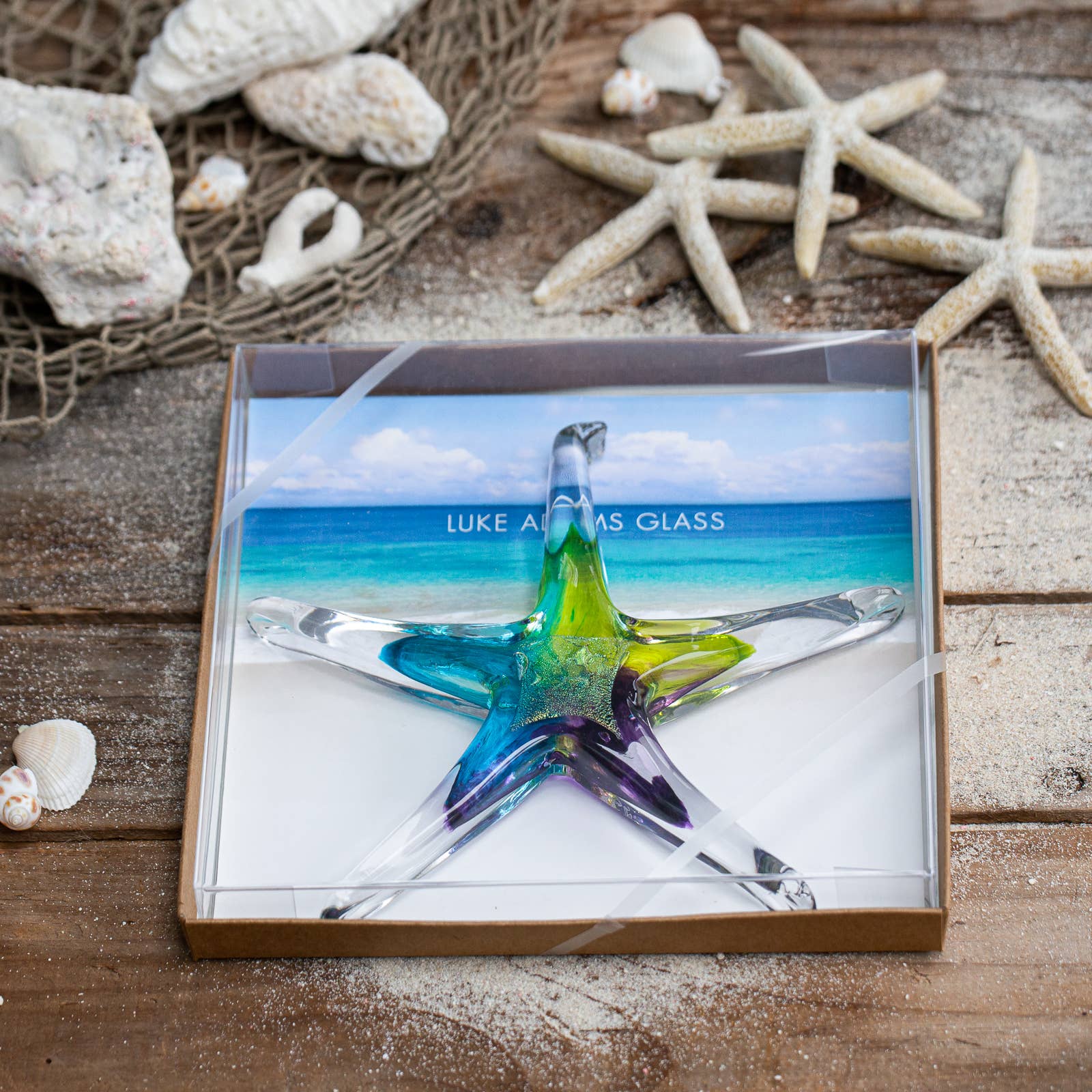 Mellow Monkey 7-inch hand-blown glass starfish ornament with vibrant blue, green, and purple hues in a gift box.