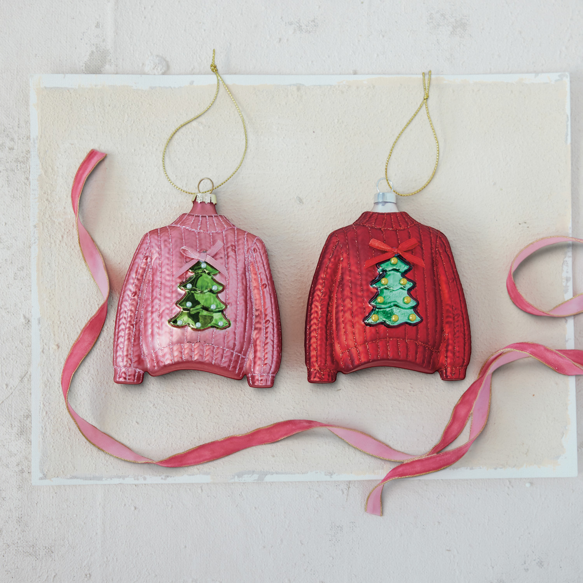 Mellow Monkey hand-painted glass sweater ornaments in pink and red with festive tree designs and ribbon bows