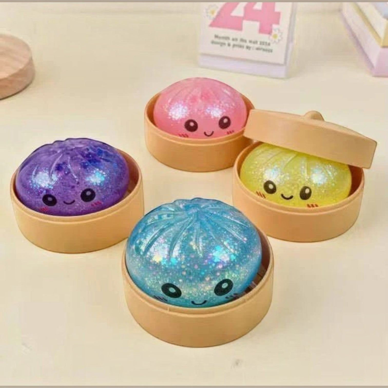 Mellow Monkey 3-inch glittery dumpling squeeze toys with cute faces in individual bamboo-style steamer baskets.