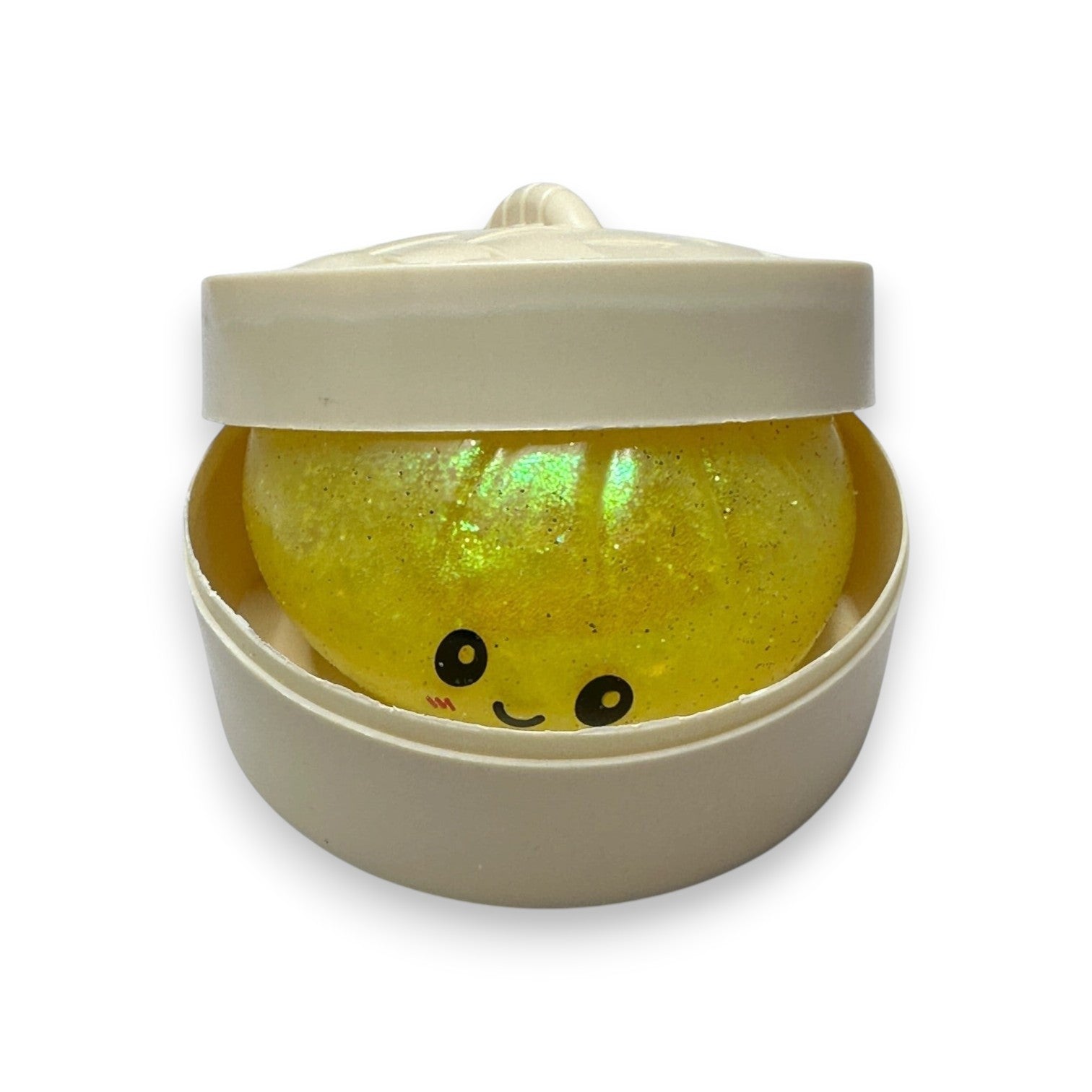 Mellow Monkey yellow glitter dumpling stress toy with a cute face inside a small plastic steamer basket container.