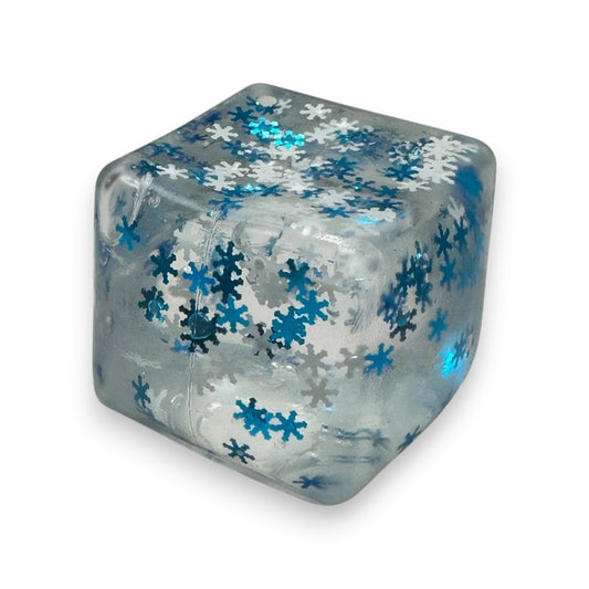 Mellow Monkey 2-inch clear squishy cube filled with blue and silver snowflake glitter for stress relief and fidgeting.
