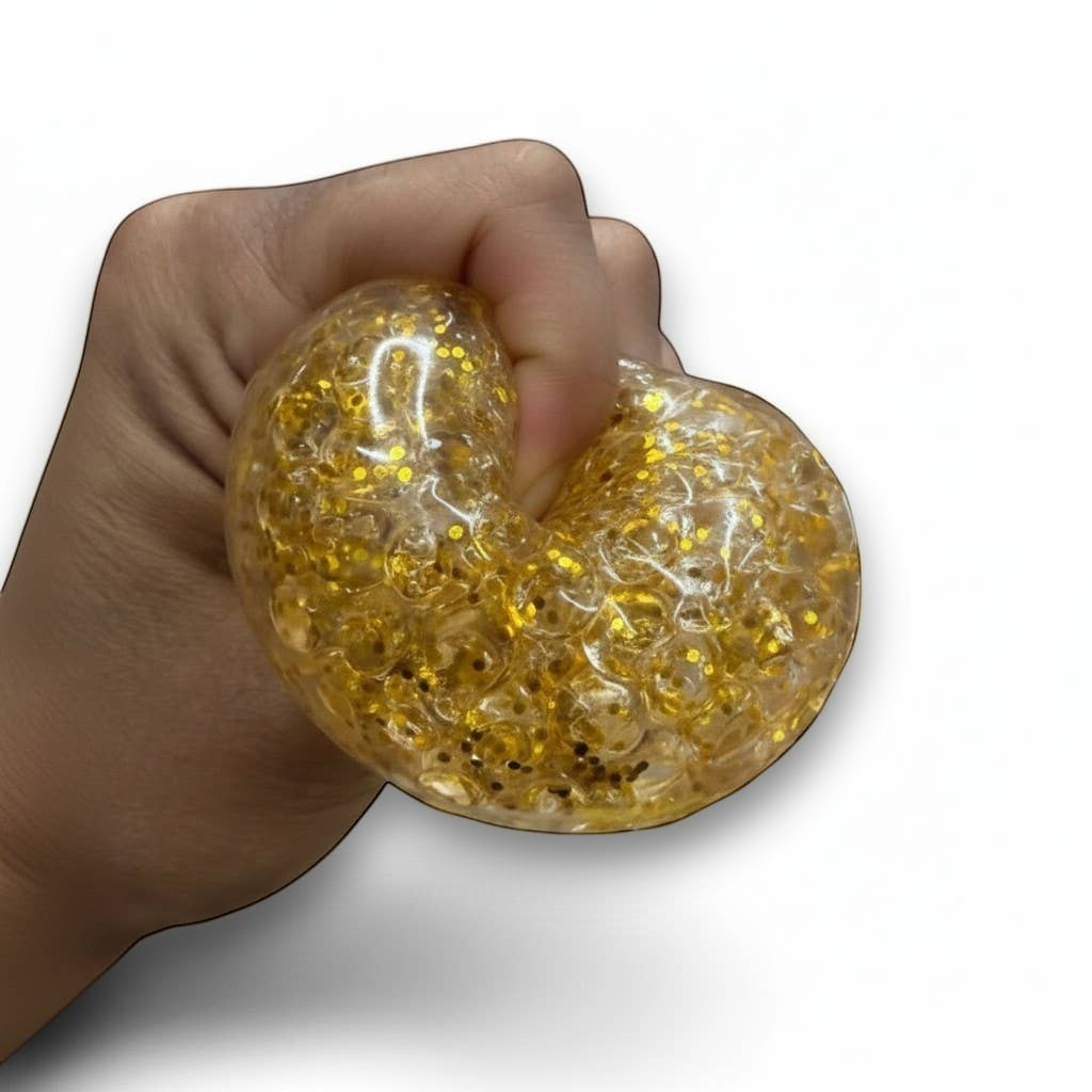 Mellow Monkey gold glitter Orbee dumpling stress relief squeeze toy being held in a hand