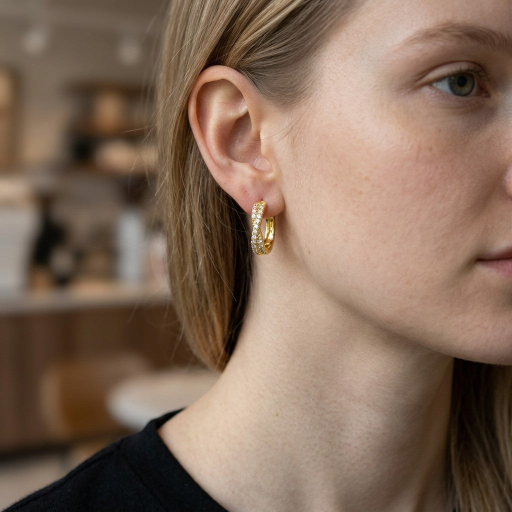 Mellow Monkey 18k gold plated twisted hoop earrings with cubic zirconia, worn by a model.