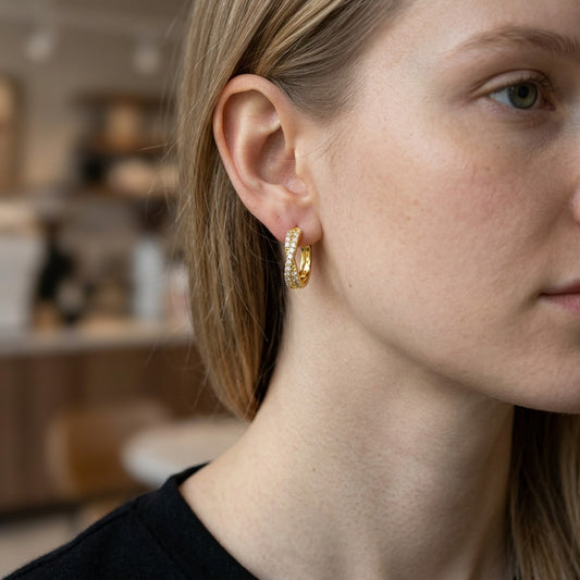 Mellow Monkey 18k gold plated twisted hoop earrings with cubic zirconia, worn by a model.