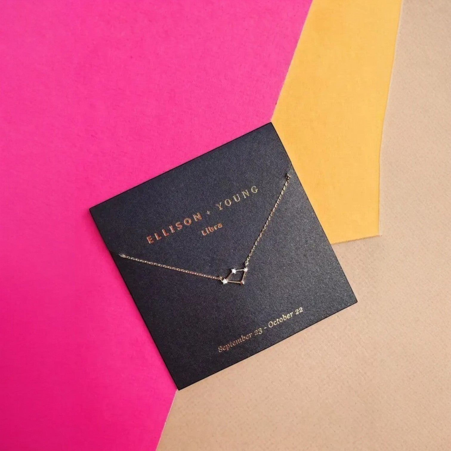 Mellow Monkey gold Libra zodiac constellation necklace with cubic zirconia accents on a black card, 16-inch length.