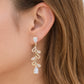 Mellow Monkey 18k gold plated dangle earrings with cubic zirconia in a vine design, featuring pear-shaped stones.