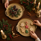 Mellow Monkey gold round trays styled with holiday cookies and pinecones on a dark wooden table