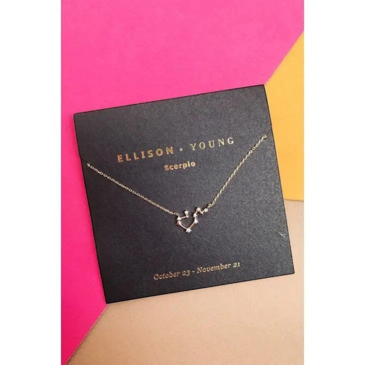 Mellow Monkey gold Scorpio constellation necklace with cubic zirconia accents on a black card with dates October 23 - November 21.