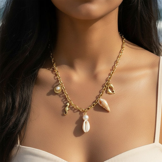 Mellow Monkey gold stainless steel necklace with sea charms: seashell, seahorse, pearl, and dolphin.