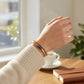 Mellow Monkey gold and blue sodalite bar bead bracelet worn on a wrist with a cozy sweater and coffee