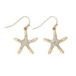 Mellow Monkey gold starfish earrings featuring clear crystal accents on a hook back, perfect for coastal style.