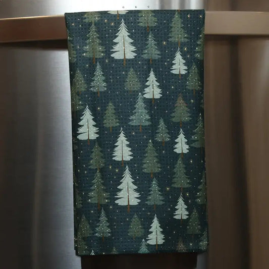 Mellow Monkey waffle weave kitchen towel with gold and green Christmas tree print on a dark background