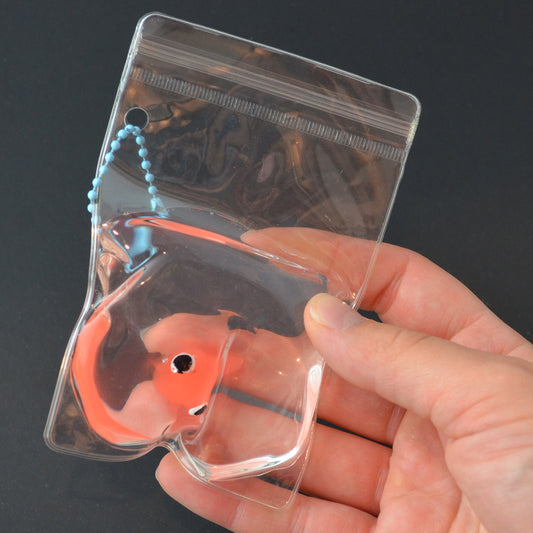 Mellow Monkey squishy orange goldfish toy inside a clear plastic bag with a blue keyring for stress relief