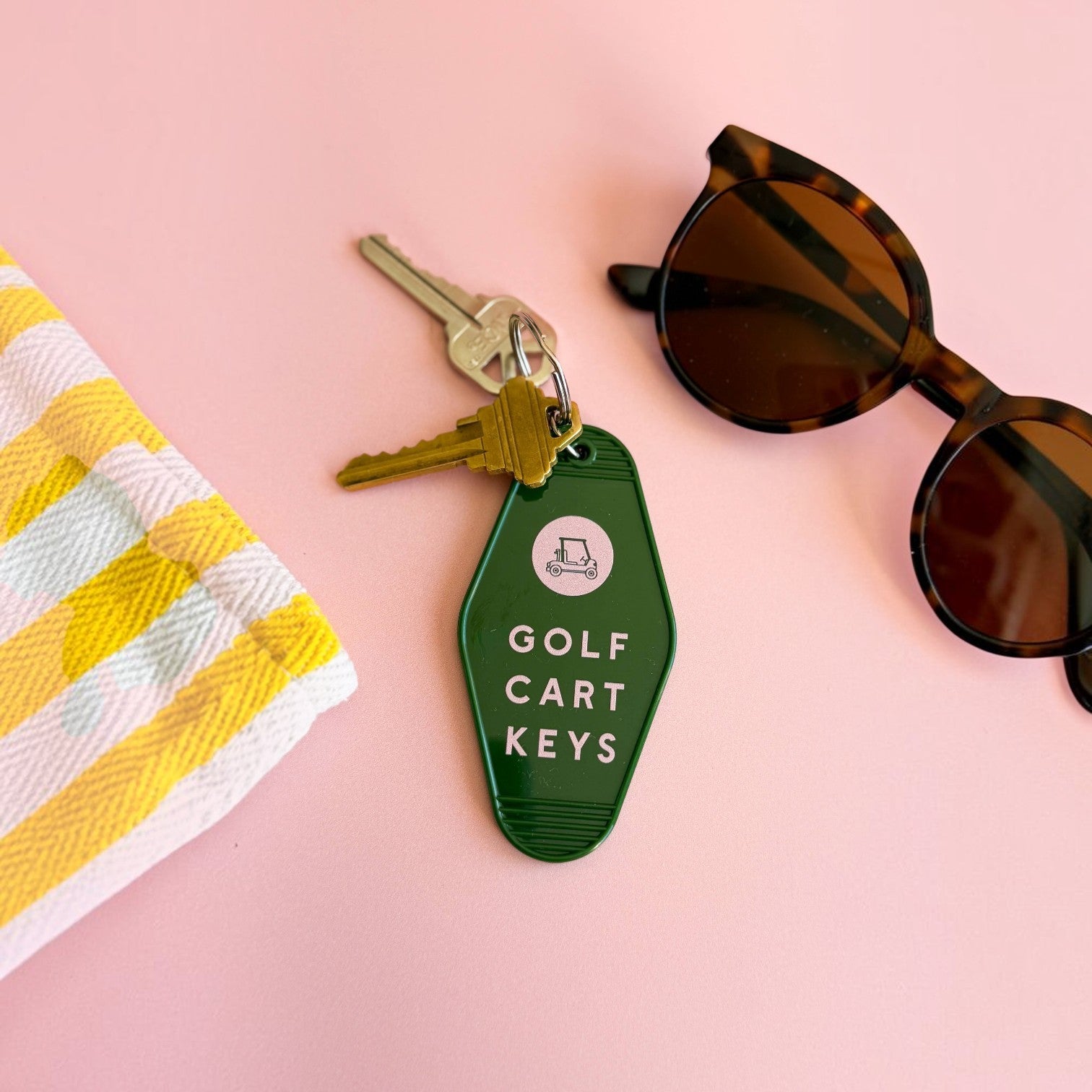 Mellow Monkey retro green motel-style keychain with Golf Cart Keys text and icon on a pink background with sunglasses.