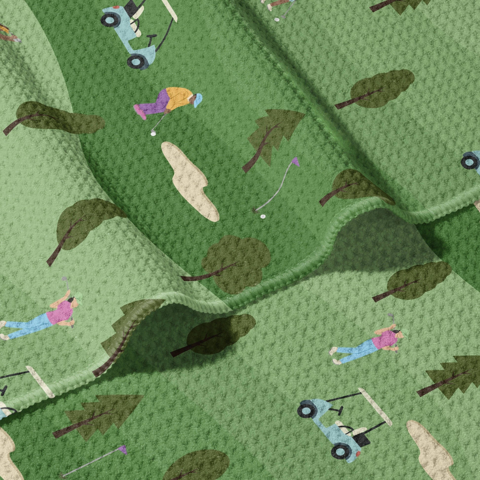 Mellow Monkey Golf Life double-sided waffle dish towel with a green golf course print, featuring golfers, golf carts, trees, and sand traps.