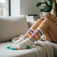 Mellow Monkey crew socks with Good Moms Say Bad Words text, featuring colorful stripes on a cream background.