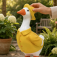 Mellow Monkey hand-painted resin goose garden statue wearing a yellow raincoat and matching hat in a garden setting