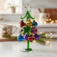 Mellow Monkey 8-inch green glass Christmas tree decorated with colorful vintage-style teardrop ornaments and a star.