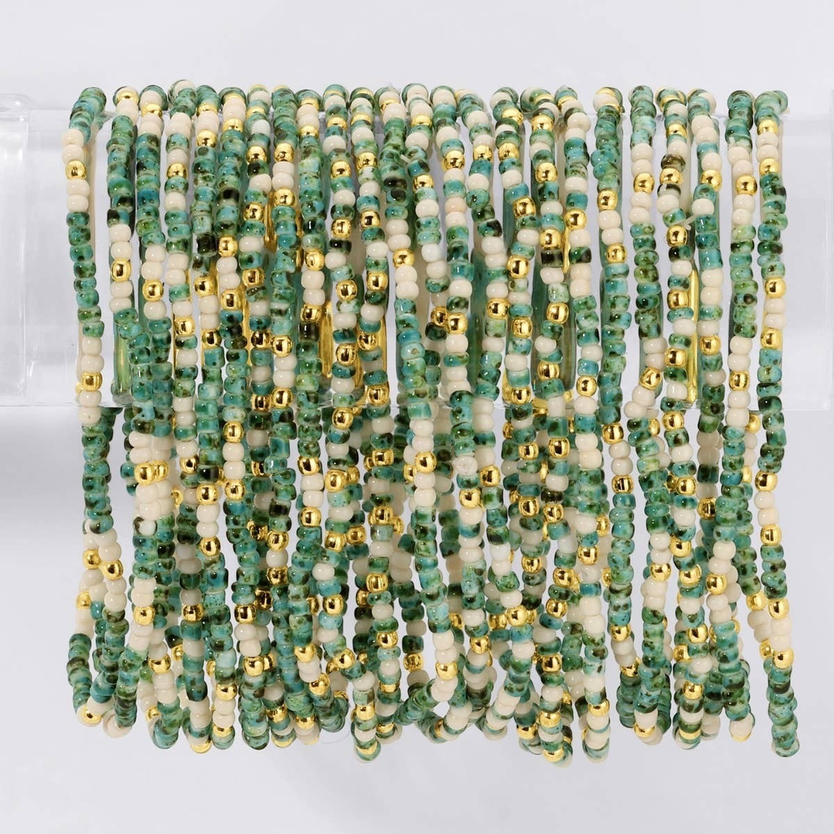 Mellow Monkey stretch bracelet set featuring green, ivory, and 18k gold plated seed beads with an organic texture.