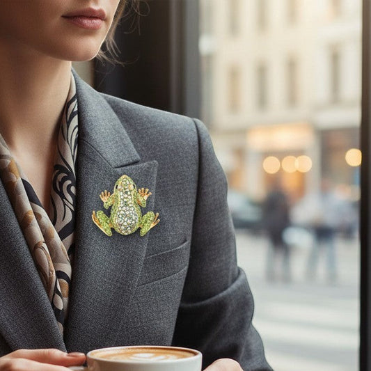 Mellow Monkey green rhinestone toad brooch pin on a grey blazer lapel.