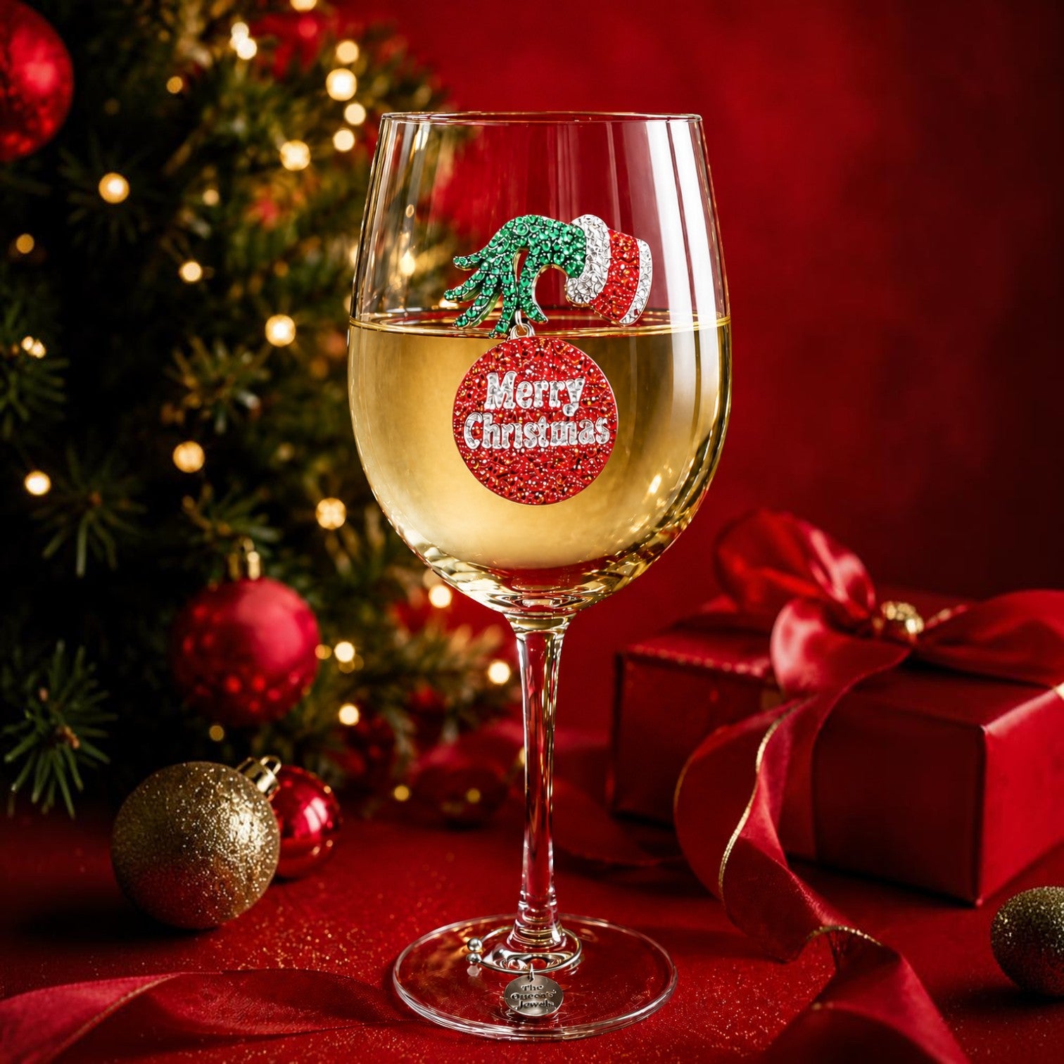 Mellow Monkey Grumpy Christmas stemmed wine glass featuring a green hand and red ornament design on a festive table.