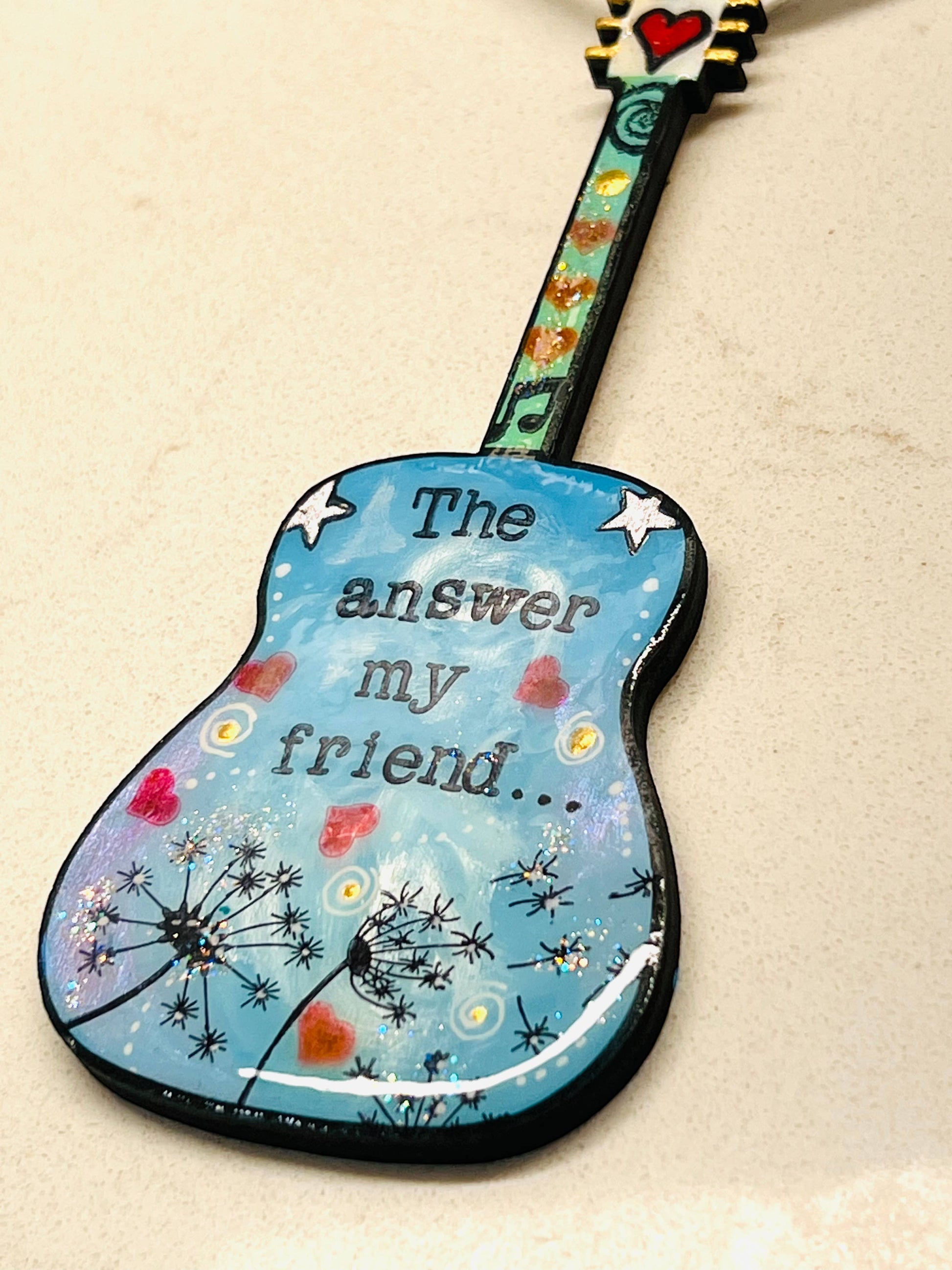 Mellow Monkey hand-painted guitar ornament featuring Bob Dylan lyrics and dandelion art on a blue background.