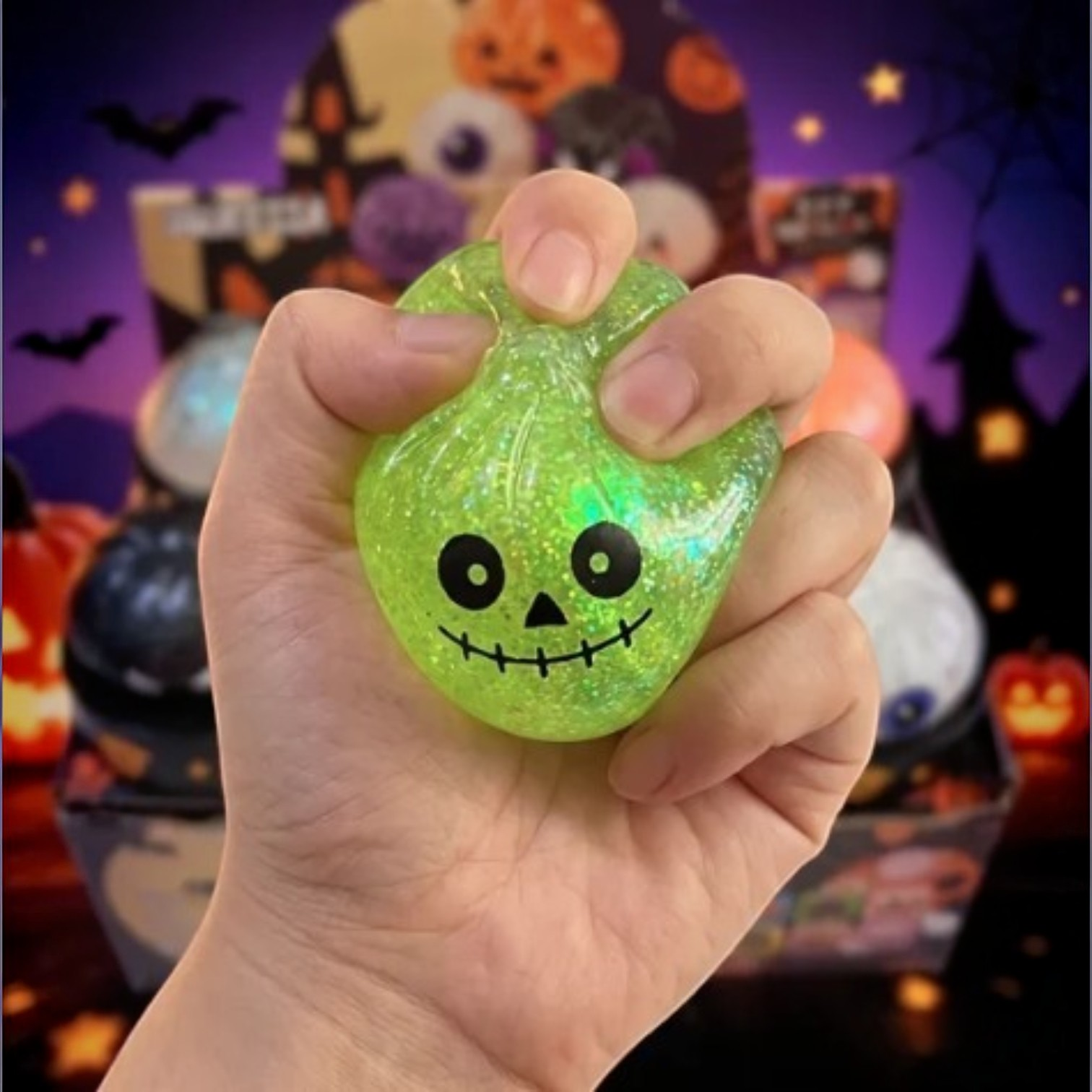 Mellow Monkey Halloween mystery squishy dumpling in a hand, featuring a green glittery pumpkin design.