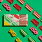 Mellow Monkey Hammond's 9 oz gift box of assorted colorful ribbon candy surrounded by loose pieces on green background