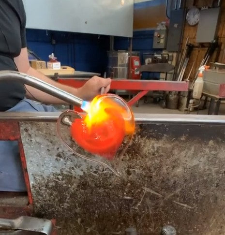 Mellow Monkey artisan hand-blown red glass heart ornament being shaped with a torch in a glassblowing studio