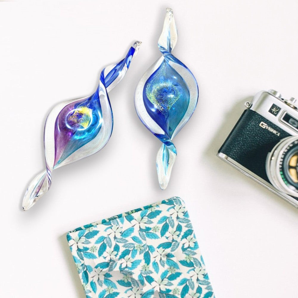 Mellow Monkey hand-blown glass spiral ornaments in blue and purple, featuring swirling light-catching designs.