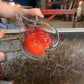 Mellow Monkey 5-inch hand-blown red glass heart ornament being crafted by an artisan in a glassblowing studio