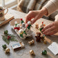 Mellow Monkey handmade wool felt mice ornaments in festive holiday outfits displayed in a rustic egg crate