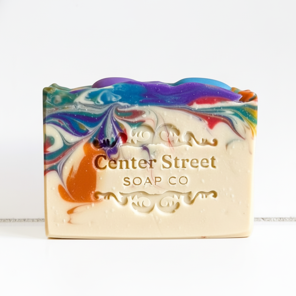 Mellow Monkey Deck The Halls handmade bar soap with a multicolored holiday lights swirl design on a white background.