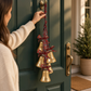 Mellow Monkey hanging holiday bells with tartan ribbon bows on a green front door