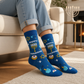 Mellow Monkey blue bamboo knit socks featuring Happy Hanukkah text, menorah, and dreidel patterns on a person.