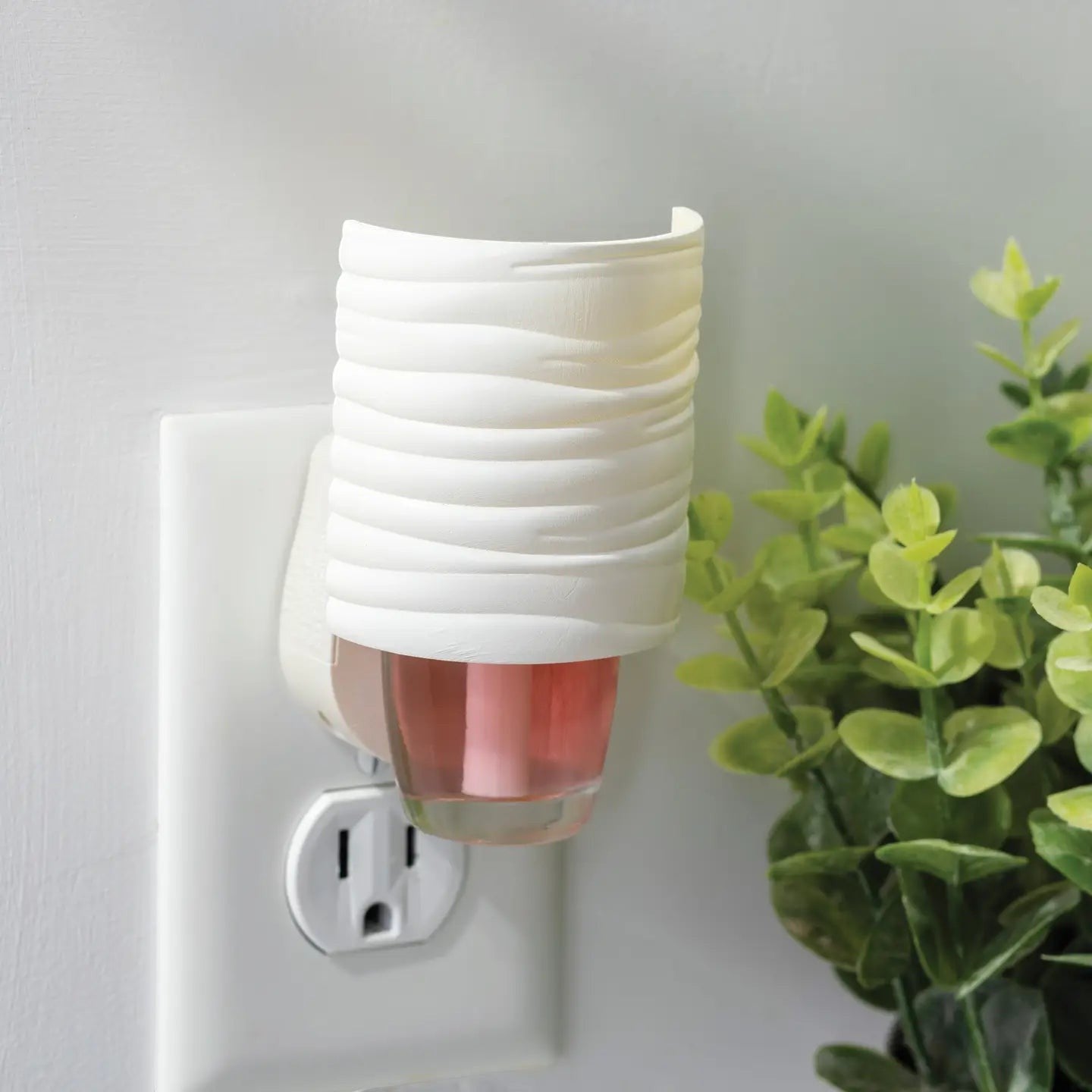 Mellow Monkey Harmony WallScents fragrance warmer with a white textured cover plugged into a wall outlet.