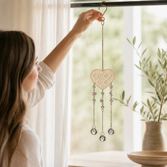 Mellow Monkey heart-shaped suncatcher with crystals and healing stones hanging in a bright window