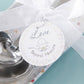 Mellow Monkey heart-shaped stainless steel measuring spoons tied with a white ribbon and baby shower gift tag