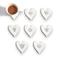 Mellow Monkey white porcelain heart-shaped coasters with black inspirational quotes and a coffee cup on one.