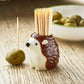 Mellow Monkey brown ceramic hedgehog toothpick holder with bamboo toothpicks on a wooden table with olives