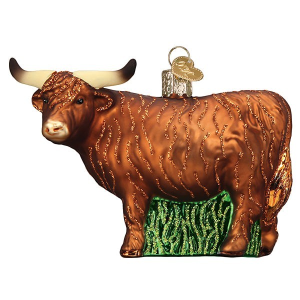 Mellow Monkey Highland Cow blown glass ornament with glittery brown coat and green grass base.