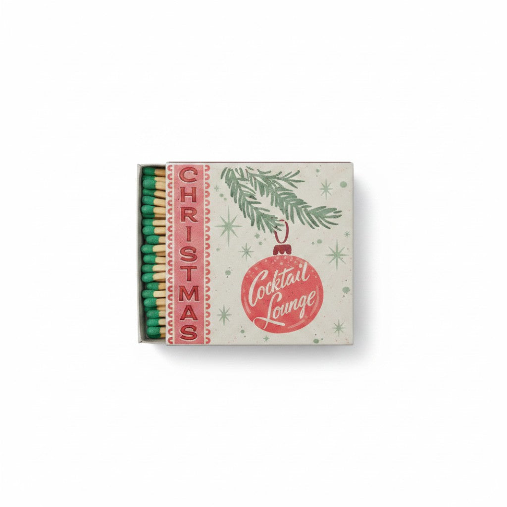 Mellow Monkey holiday matchbox featuring a red Christmas ornament graphic and green matchsticks in a retro style.