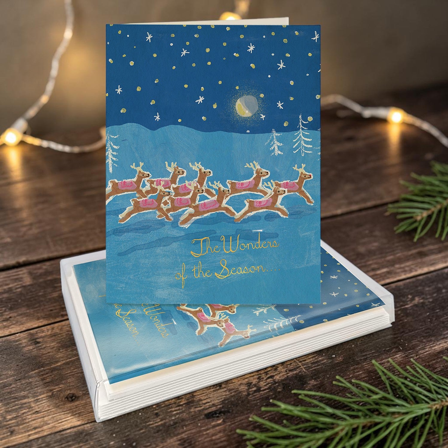 Mellow Monkey boxed holiday cards featuring a blue night scene with flying reindeer and the text The Wonders of the Season