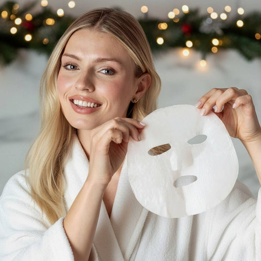 Mellow Monkey woman in a white robe holding a single-use sheet mask for holiday skincare