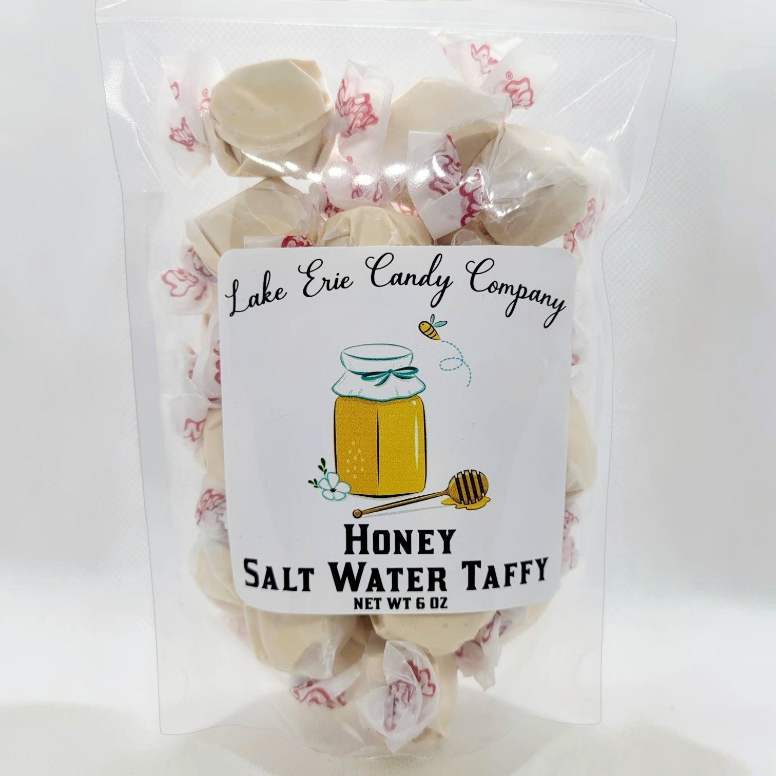 Mellow Monkey Honey Salt Water Taffy, creamy, golden candy individually wrapped in wax paper with red floral accents.