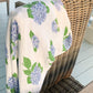 Mellow Monkey hydrangea print muslin swaddle blanket in soft bamboo and organic cotton draped over a wicker chair.