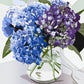 Mellow Monkey paint by number kit featuring a vibrant bouquet of blue and purple hydrangeas in a clear glass vase.