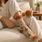 Mellow Monkey bamboo knit socks in light tan with pixelated iced coffee cups and terracotta accents on a person.