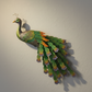 Mellow Monkey Imperial Peacock wall decor featuring embossed jewel-toned feathers in emerald, sapphire, and gold.
